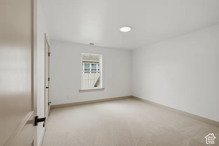 Neutral wall finishes, recessed ceiling light, window, and carpeted flooring