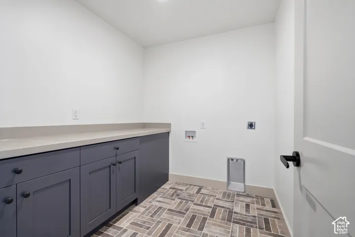 Built-in cabinetry with matte black hardware, light-toned countertop, and patterned tile flooring