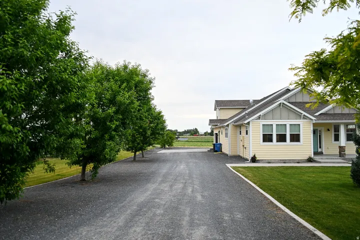 Light yellow siding with white trim, a gabled roof, and a covered porch