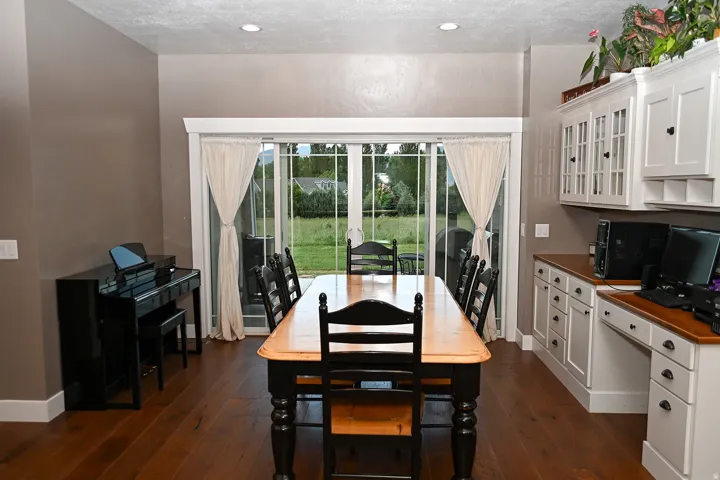 Wood-finish flooring, recessed lighting, and a built-in desk with overhead cabinetry