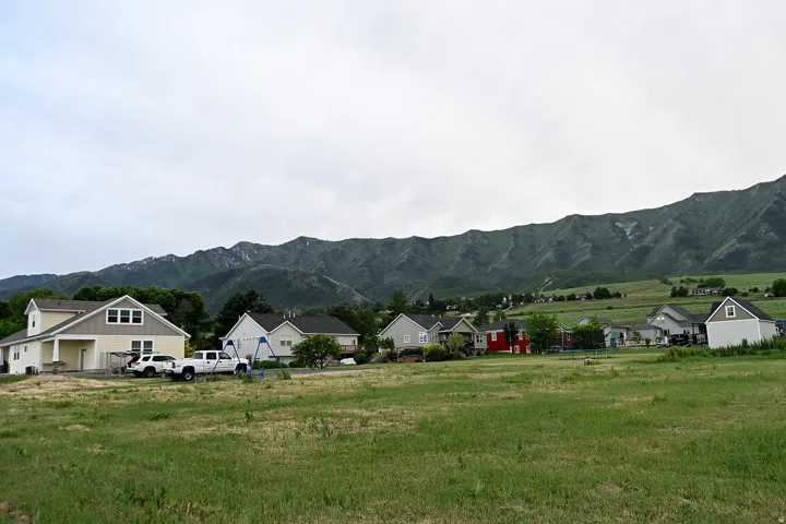 Expansive green space with mountain backdrop, surrounded by residential properties