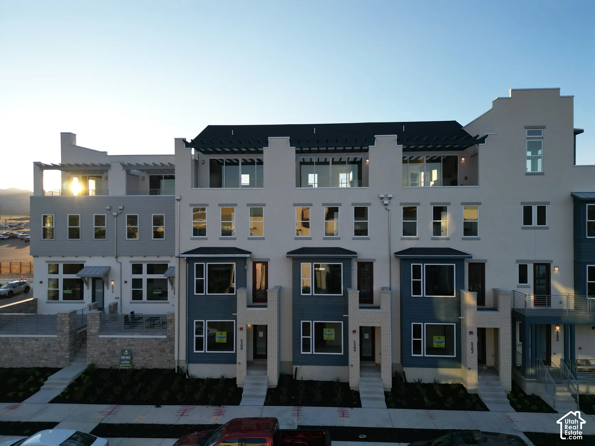 Multi-level facades with varying material applications, ground-level entryways, and upper-story balconies