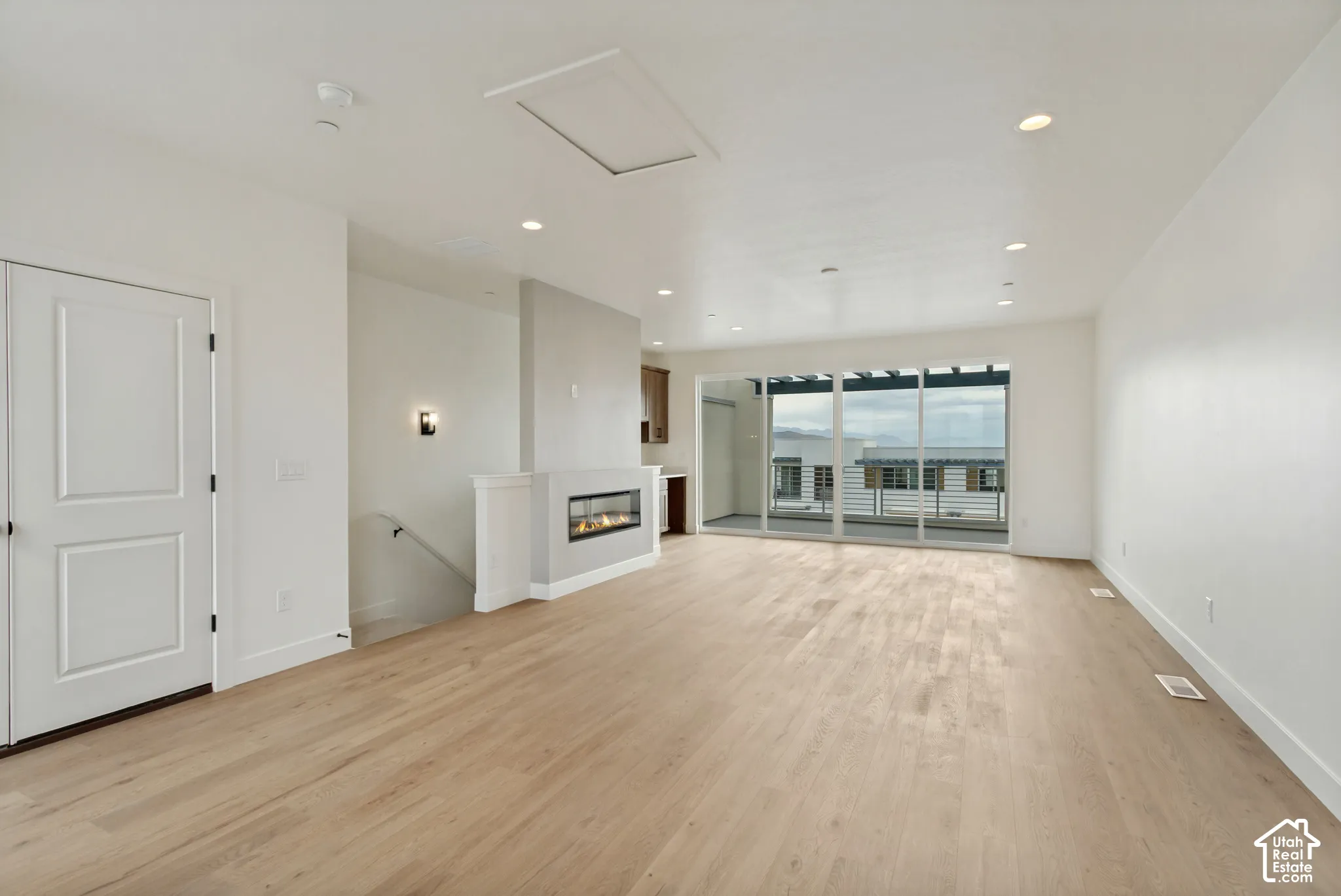 Wood-finish flooring, recessed lighting, and a modern linear fireplace