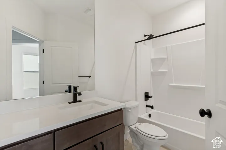 White bathroom featuring a single vanity with dark wood-finish cabinetry, white countertop, and integrated sink