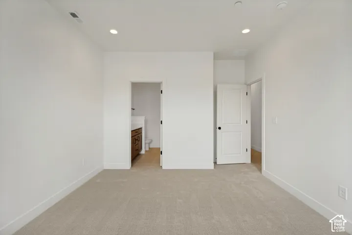 Plush carpeting, recessed lighting, and white interior doors with black hardware