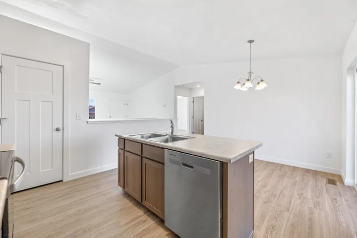 Kitchen island featuring a double-basin stainless steel sink and integrated dishwasher