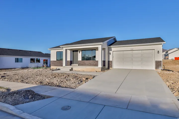 Contemporary exterior with stone accent siding, a two-car garage, and a concrete driveway