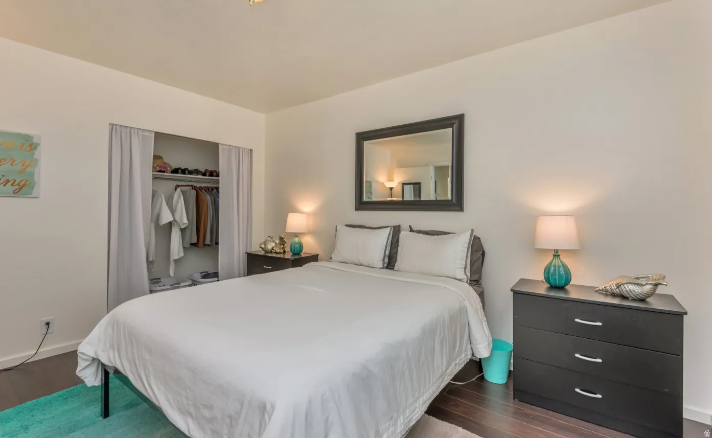 Recessed open closet with curtain closure, dark wood-finish flooring, and light-toned walls
