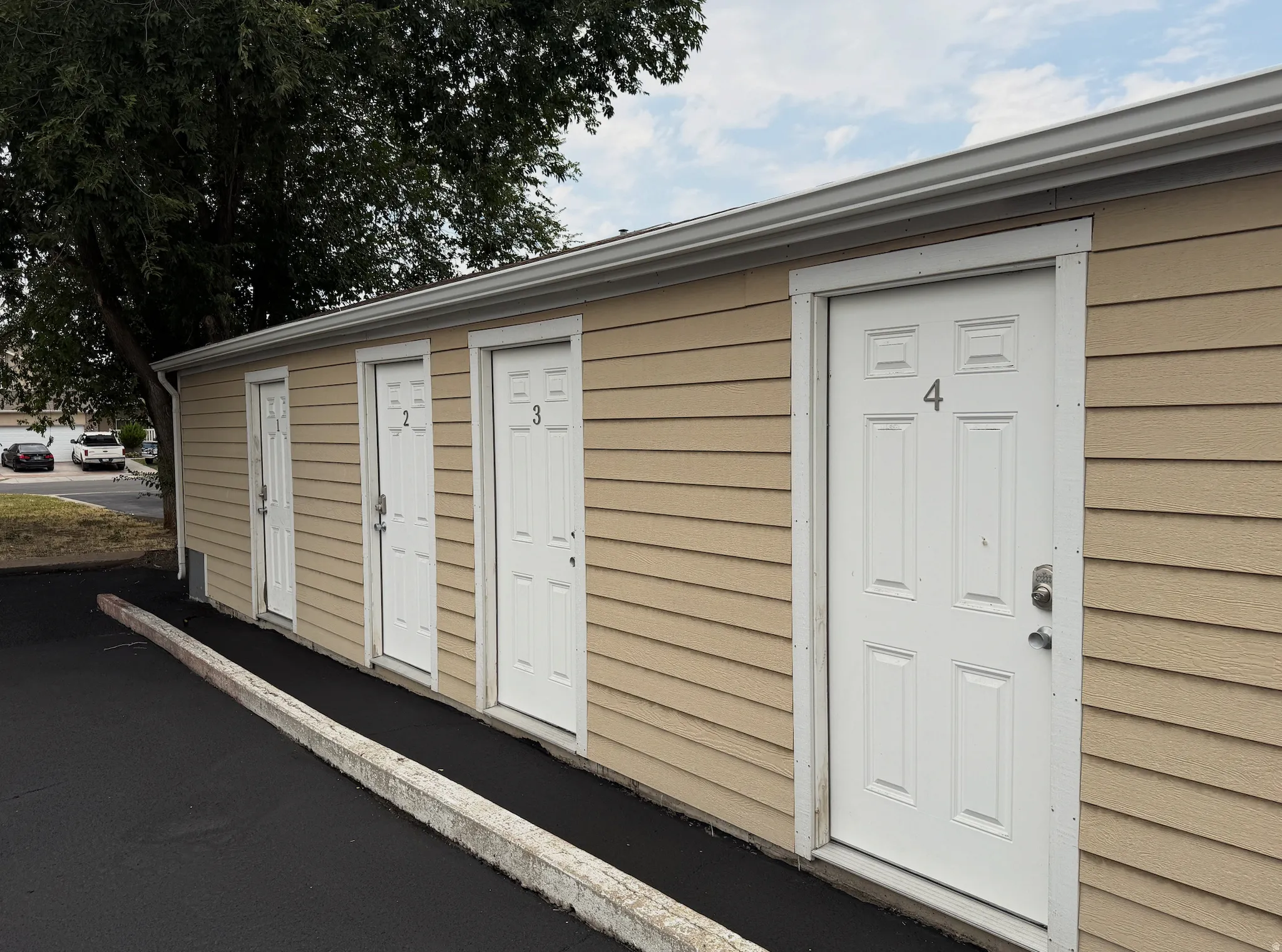Tan horizontal siding exterior with multiple white panel doors
