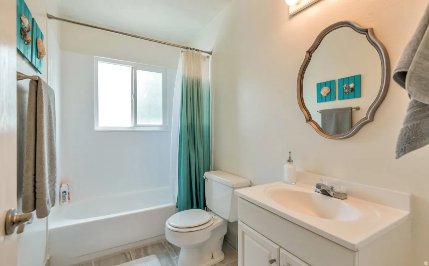 Full bathroom featuring a single vanity, integrated sink, and built-in bathtub with shower