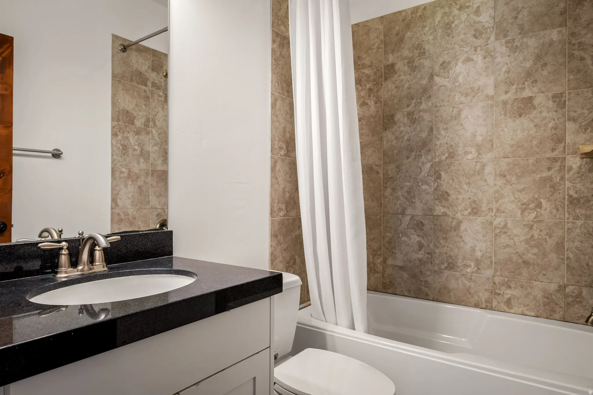 White vanity with a black countertop and an undermount sink