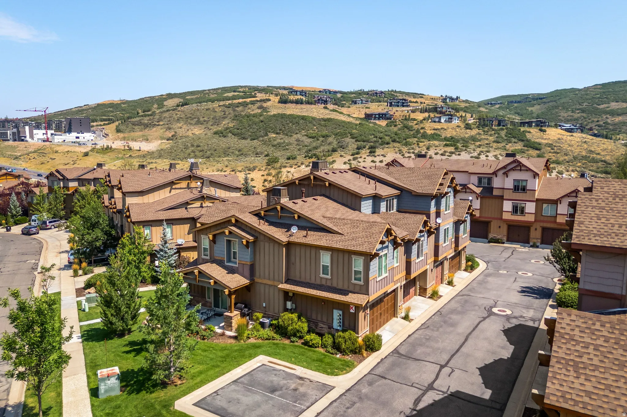 Townhome exteriors featuring wood siding, asphalt shingle roofs, and attached garages