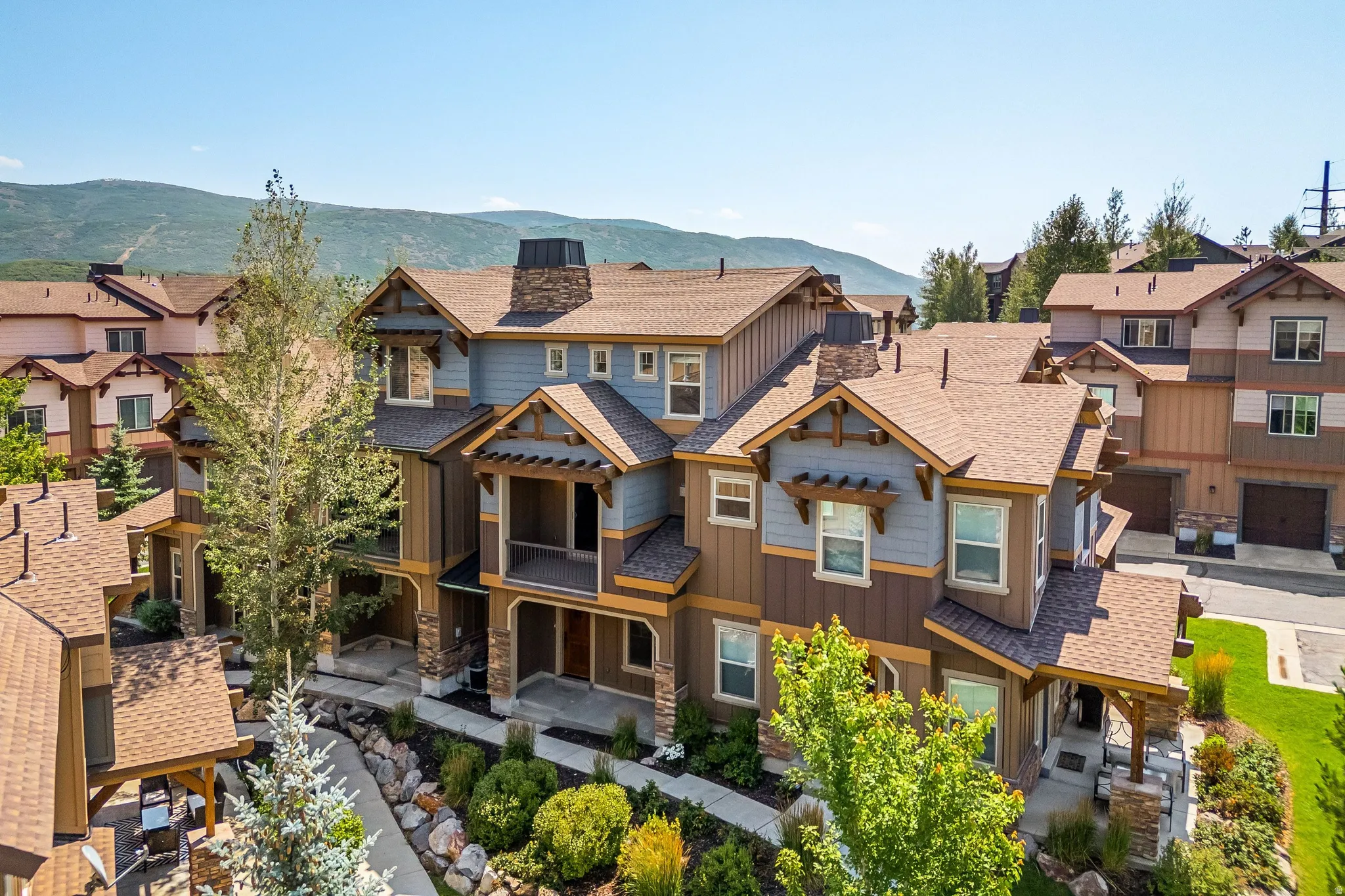 Multi-level facade with mixed siding, stone accents, and covered entryways