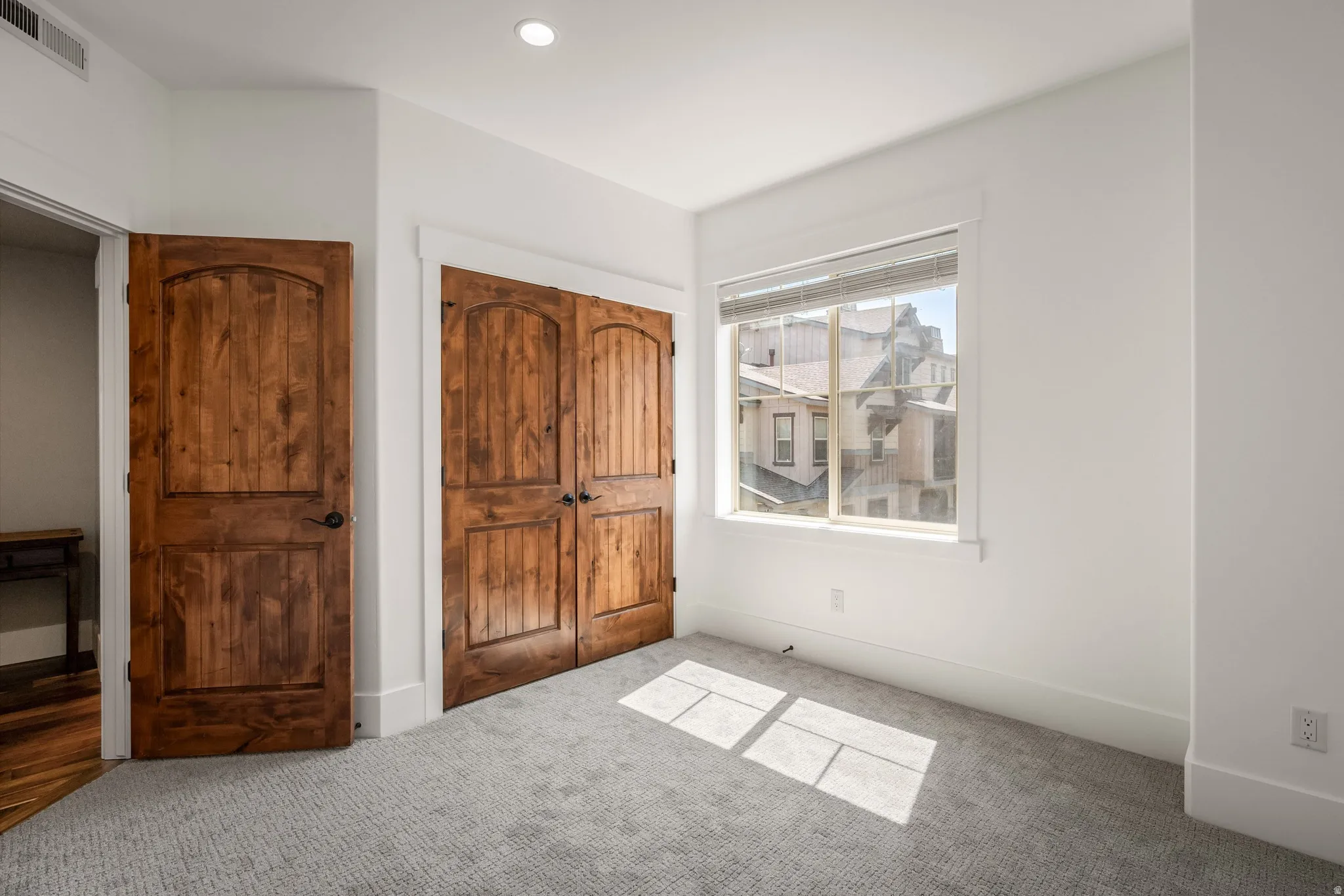 Recessed lighting, wood-finish doors, built-in closet, carpeted flooring, and a single window