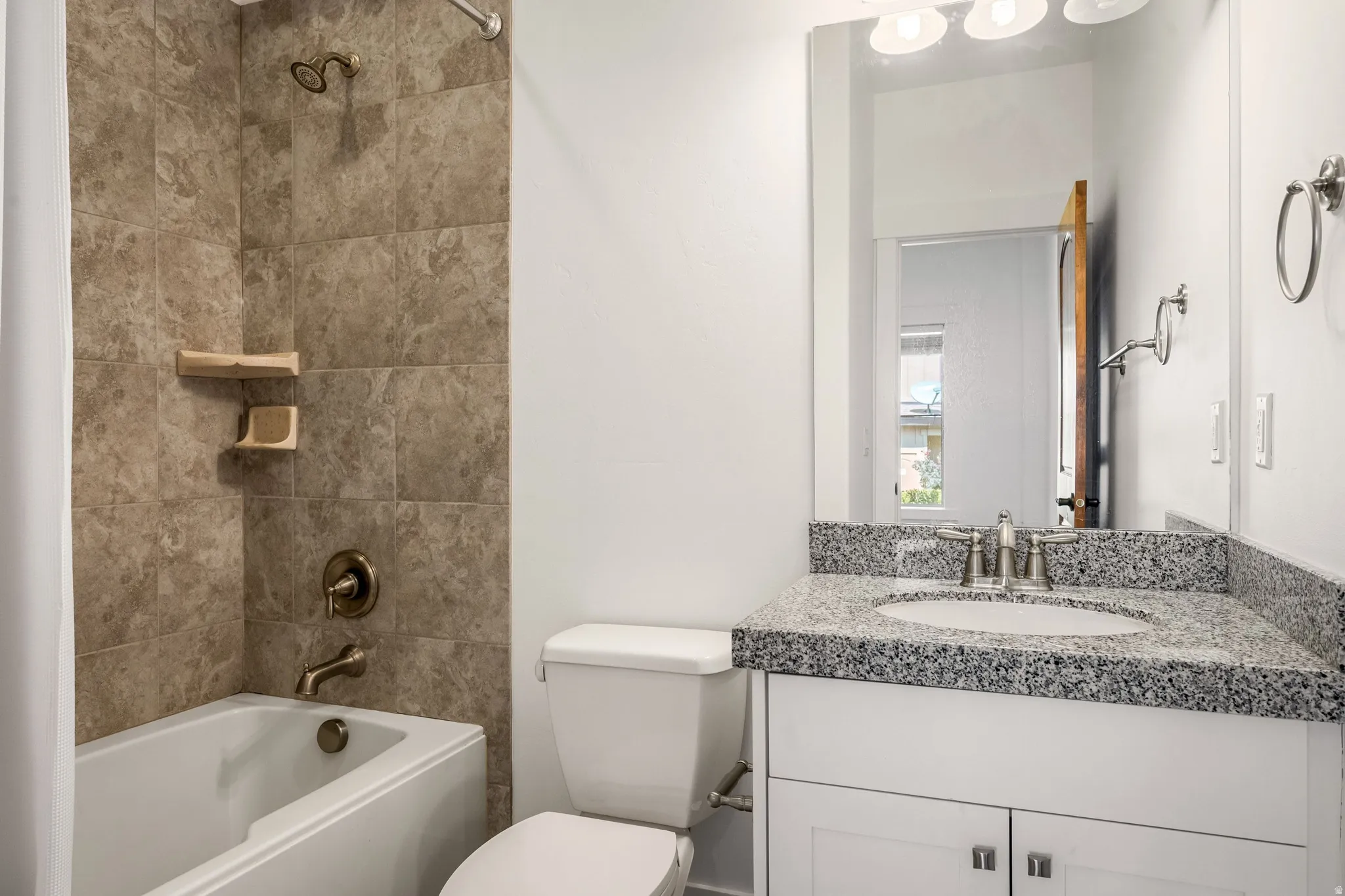 White vanity with dual-door cabinetry, a drop-in sink, and granite countertop
