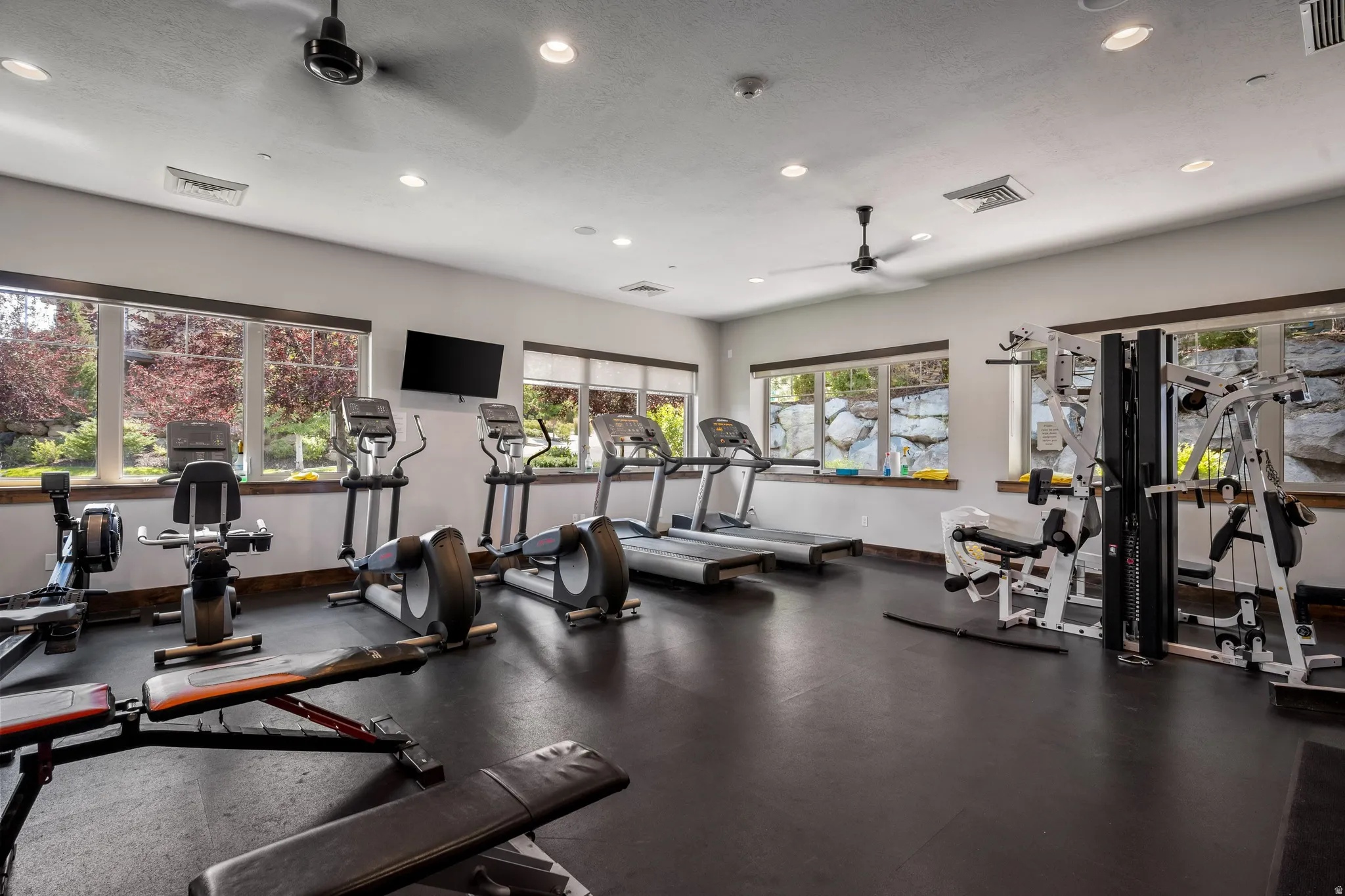 Dedicated fitness room featuring recessed lighting, multiple windows, and rubberized flooring