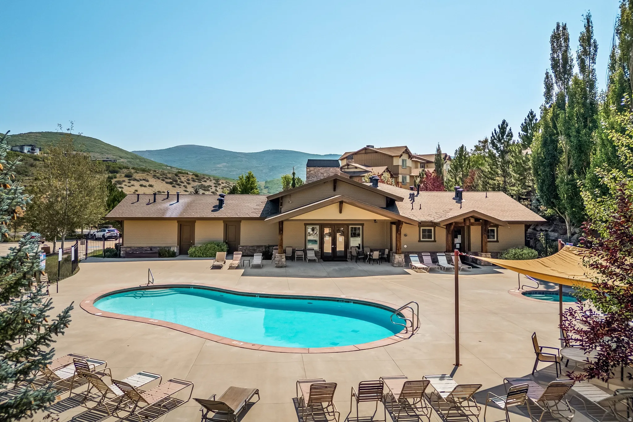Expansive outdoor pool with integrated spa and surrounding concrete decking