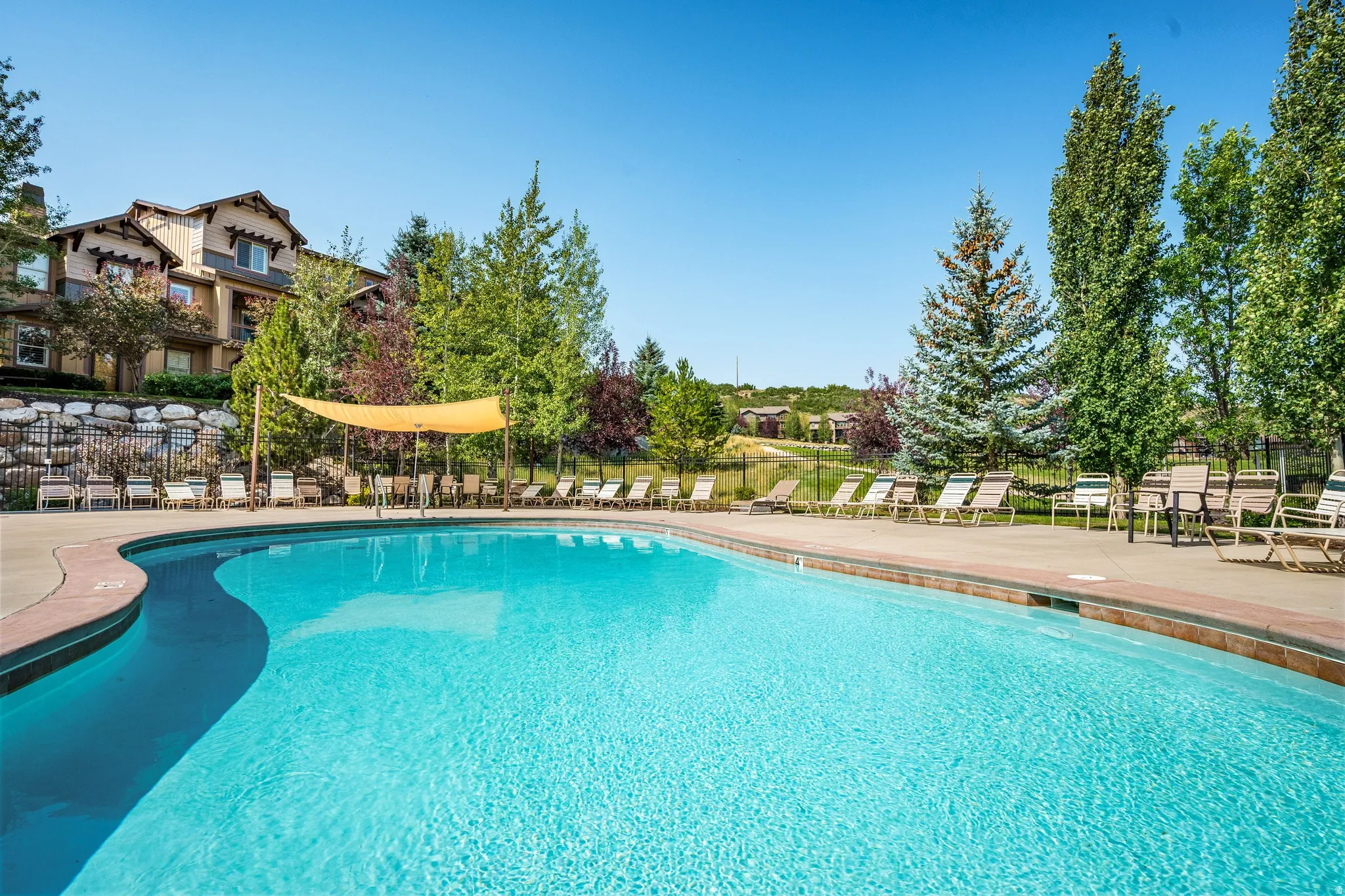 Resort-style pool with a curved edge and surrounding paved deck