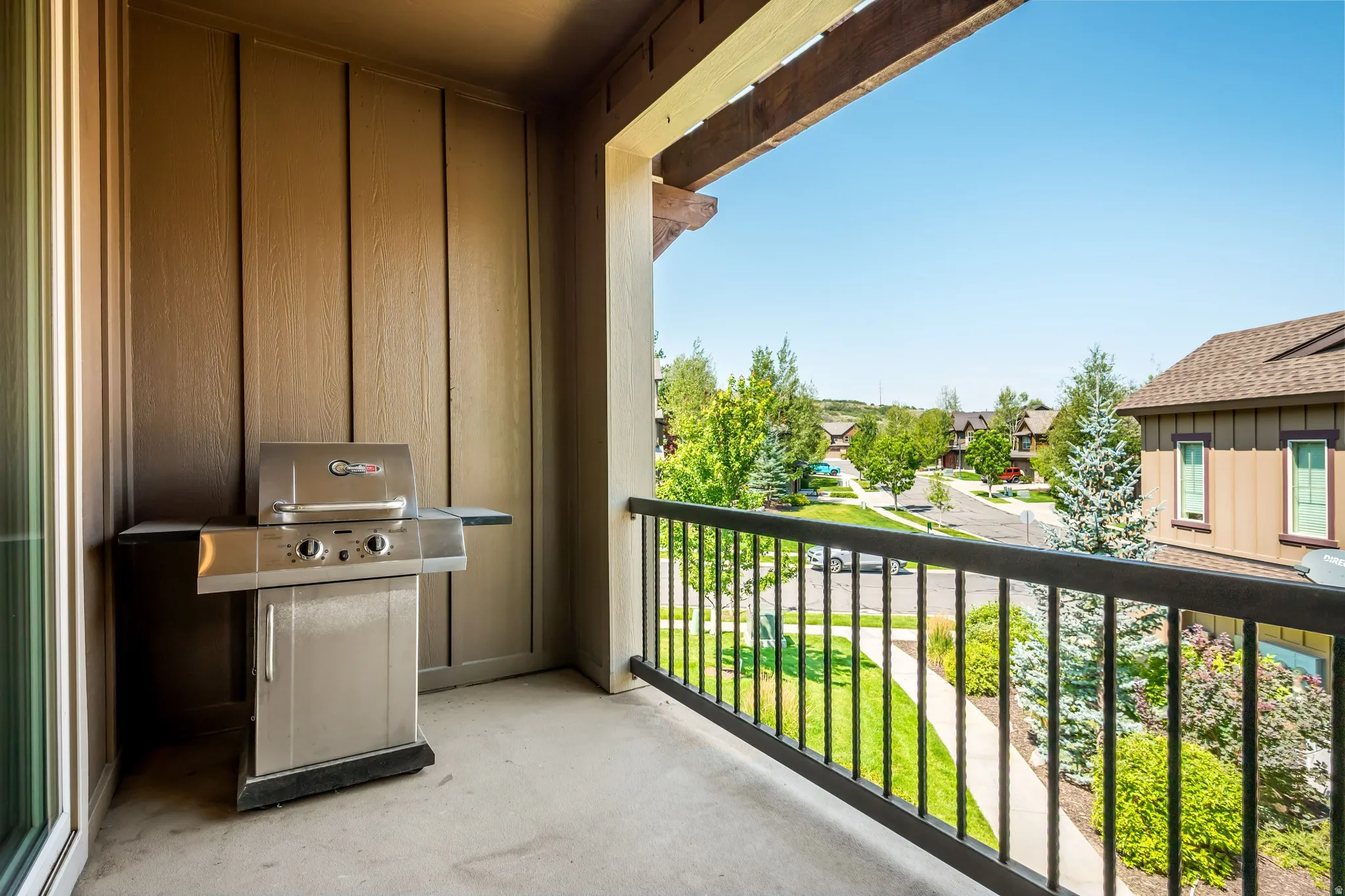 Private balcony with a concrete surface and dark metal railing