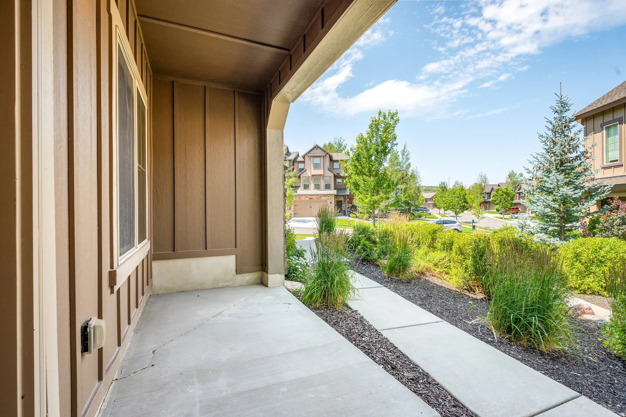 Covered front porch featuring concrete flooring and board-and-batten siding
