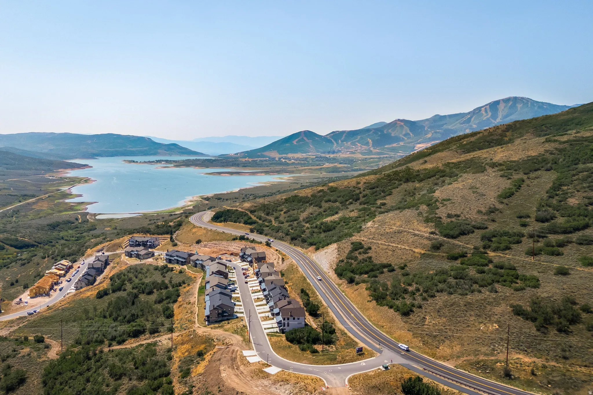 Hillside residences featuring a prominent lake and surrounding mountains