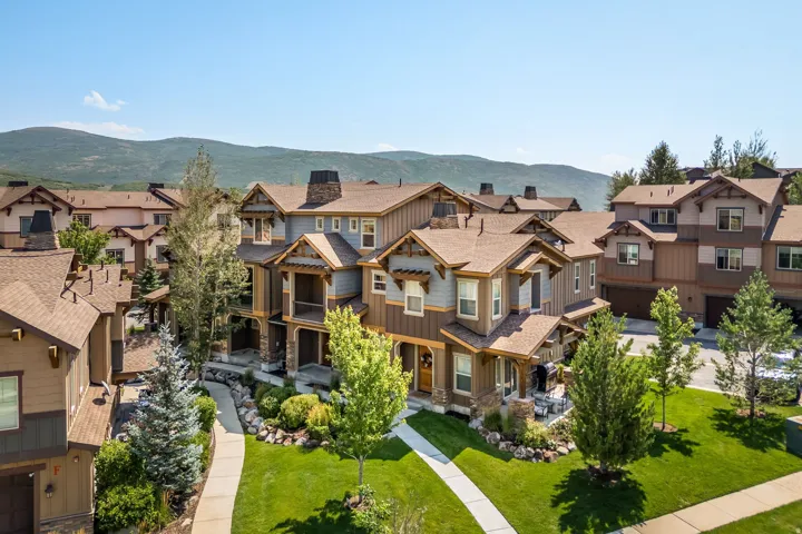 Multiple-story residences with varied exterior finishes, gabled roofs, stone accents, and covered porches