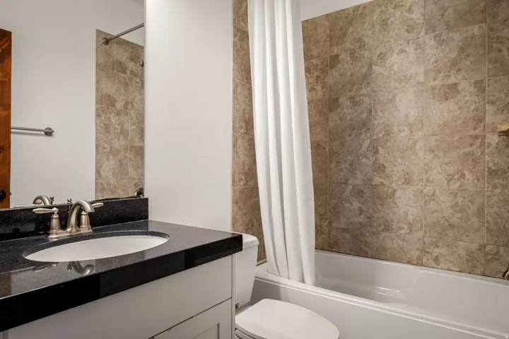 White vanity with a black countertop and an undermount sink