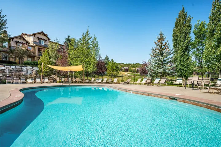 Resort-style pool with a curved edge and surrounding paved deck