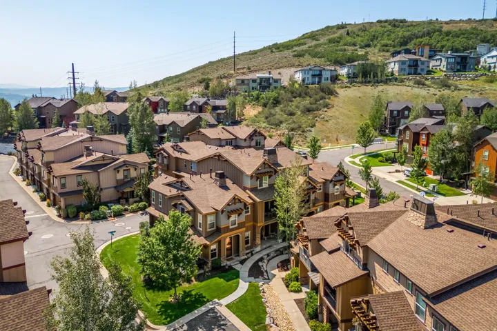 Hillside community featuring residential structures with brown shingle roofing, visible street infrastructure, and green spaces