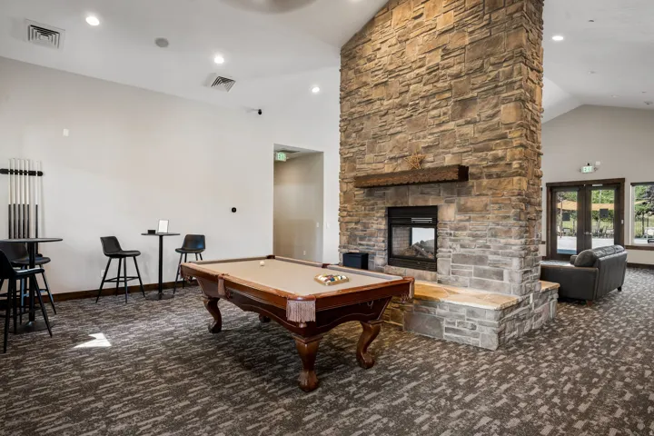 Stone-finish fireplace with a substantial hearth, vaulted ceiling, and recessed lighting