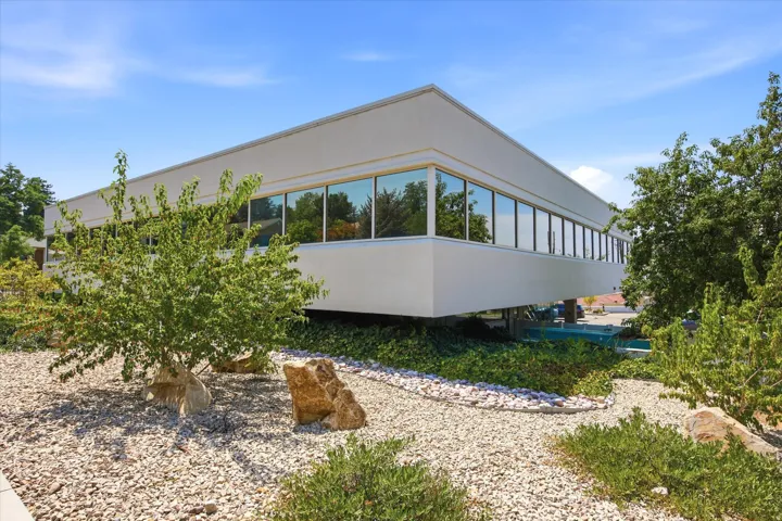 Modern exterior with extensive ribbon windows, white facade, and surrounding xeriscaping
