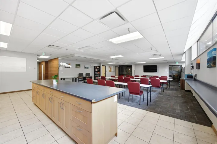 Expansive room featuring a large central island with storage, tile flooring, and broad window-style openings