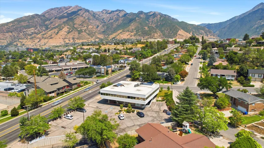 Expansive mountain backdrop with a commercial building and surrounding residential properties