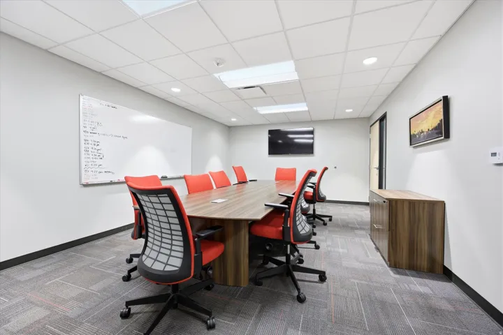 Conference room featuring a wood-finish table, recessed lighting, and drop ceiling