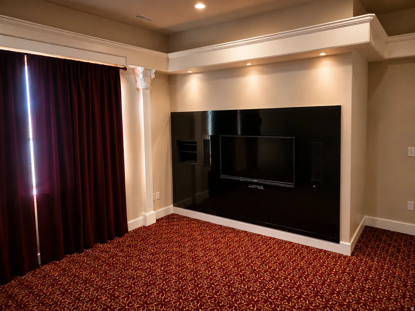 Built-in media center with recessed shelving, integrated television, and accent lighting