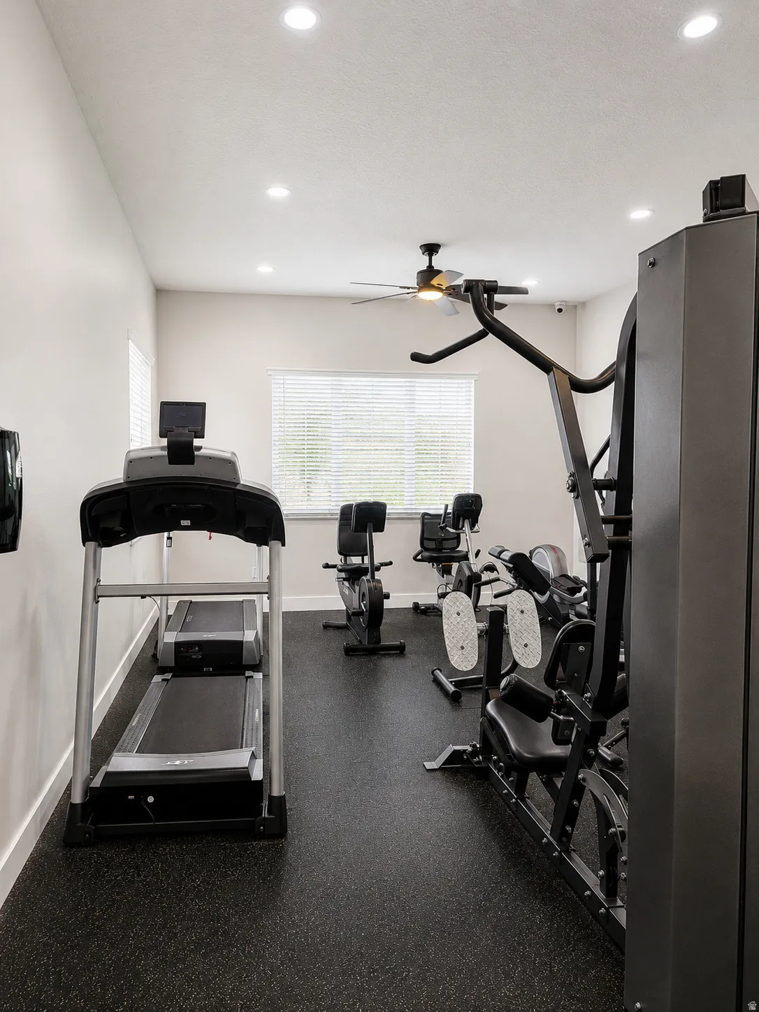 Dedicated fitness area featuring recessed lighting, a ceiling fan, and durable rubber flooring