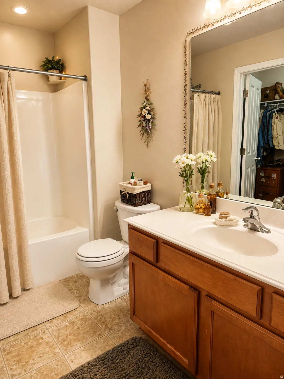 Primary's Built-in bathtub with shower, white vanity with integrated sink, wood-finish cabinetry, and tiled flooring