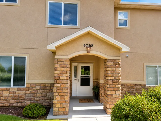 Stucco exterior with stone veneer accents, & covered entry.