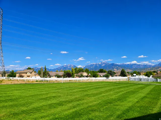 Expansive green space with distant mountain ranges and a paved trail just outside the back sliding door.