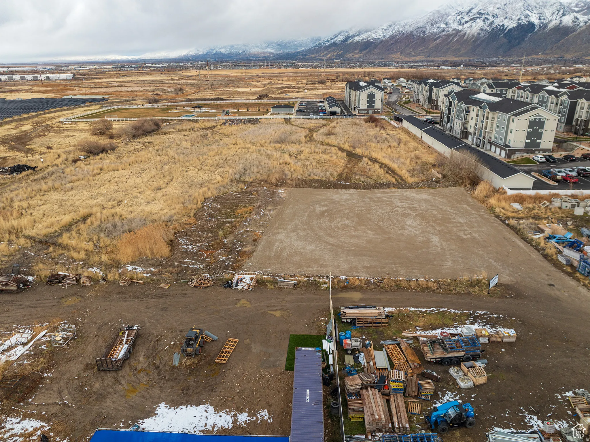 Expansive land parcel with surrounding development and mountainous backdrop