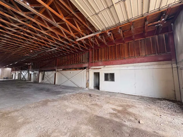 Exposed wood beam ceiling, corrugated metal roofing, metal support beams, interior window, and an interior door