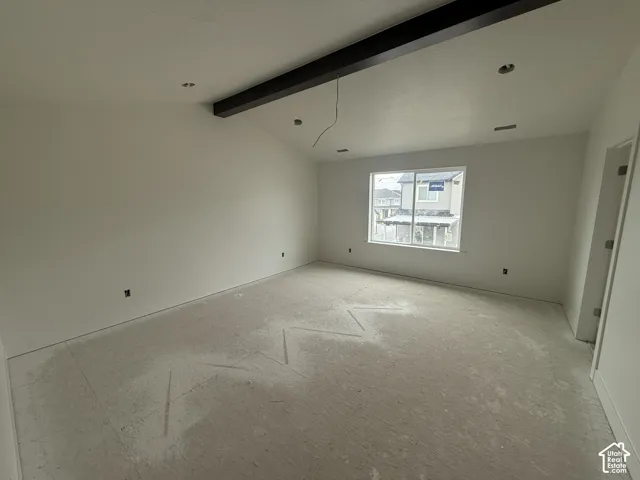 Primary Bedroom with Vaulted ceilings featuring a dark-finish exposed structural beam and recessed lighting