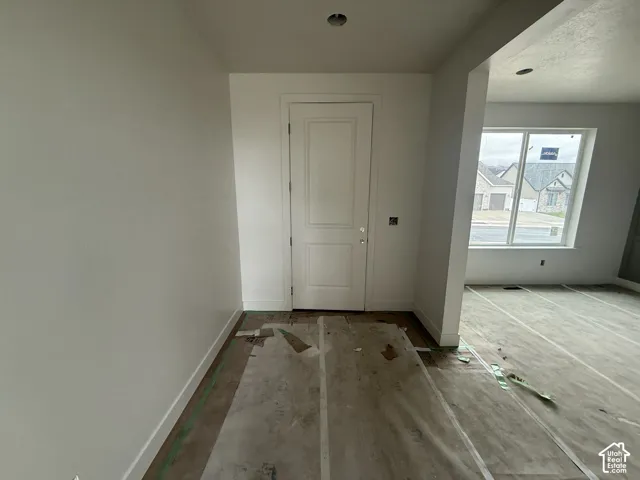 Interior space featuring a white two-panel door, neutral wall finishes, and a large window providing natural light