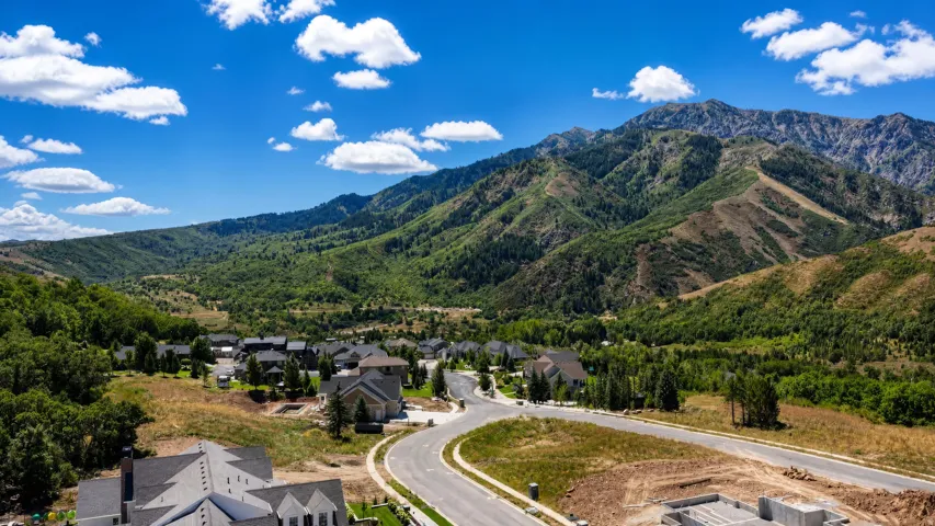 Mountainous terrain with natural landscaping, a developed residential community, and curved roadways