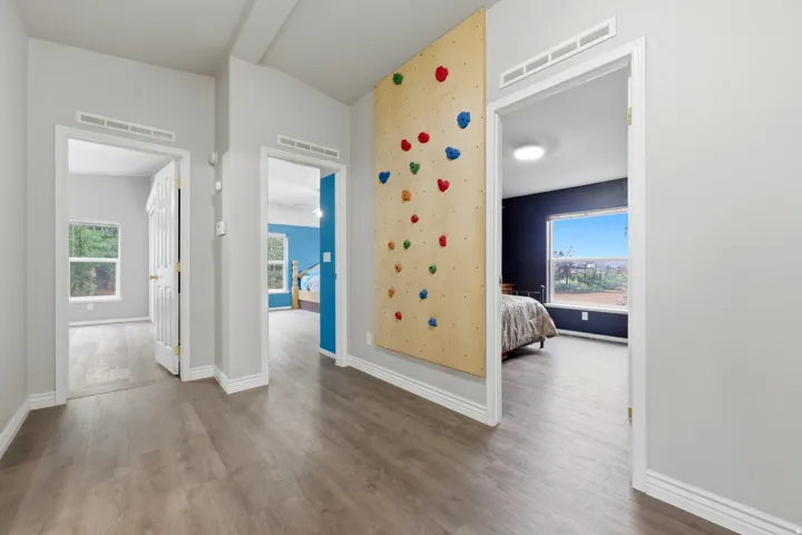Hallway with wood-finish flooring, light gray walls, and white trim