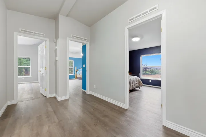 Wood-finish flooring throughout, white trim, and light gray wall paint