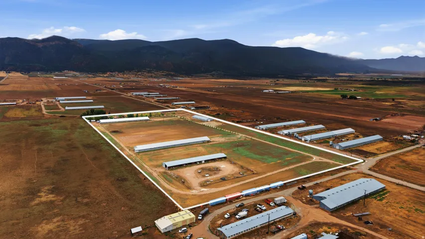 Multiple large agricultural structures, expansive open fields, and distinct property boundaries