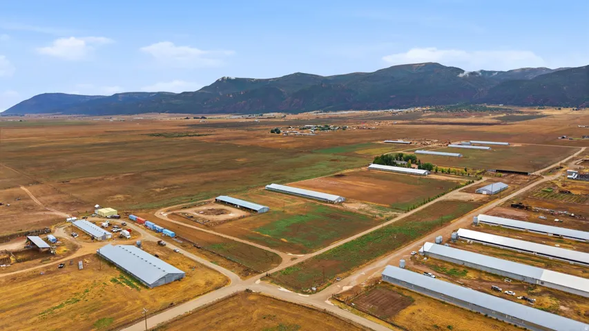 Expansive land with multiple agricultural structures and cultivated fields