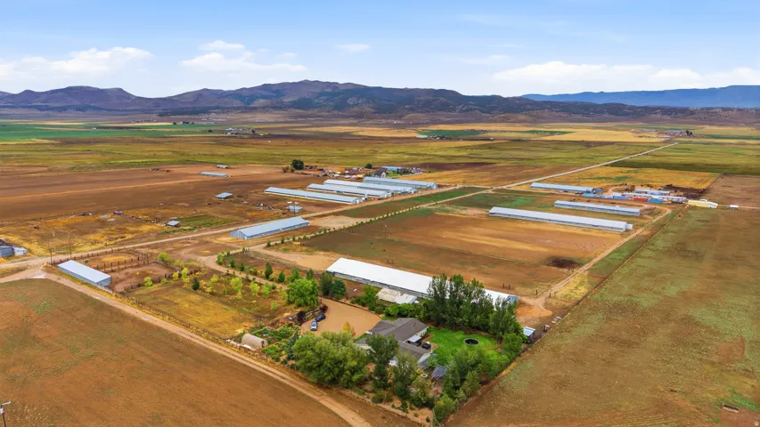 Expansive agricultural property featuring multiple outbuildings and large cultivated fields