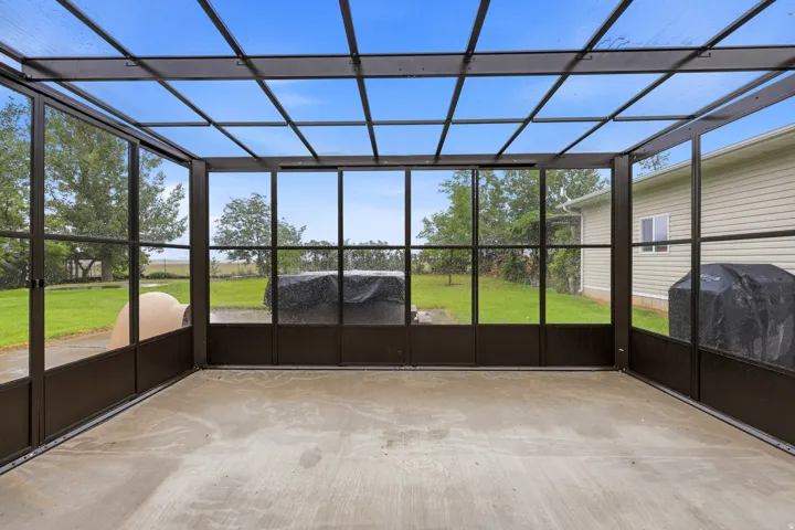 Screened enclosure featuring a translucent panel roof, concrete flooring, and full-height screen panels